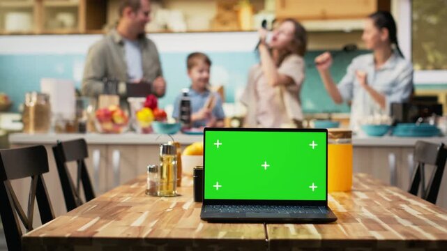 Mockup screen on laptop with cheerful family making homemade pizza, cooking in a cozy kitchen. Parents and kids laugh while adding mozzarella and vegetables, weekend bonding. Camera B.