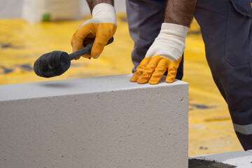 The bricklayer is working. Building a wall of aerated concrete. Gasbeton wall