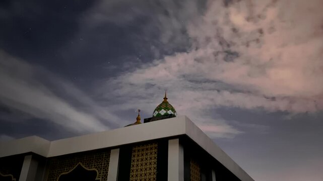 Time lapse of a majestic mosque dome under a starry night sky with moving clouds