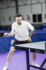 Fototapeta premium Man playing table tennis hitting ping pong ball