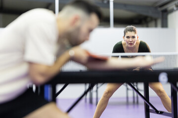 Fototapeta premium Young woman concentrating playing competitive table tennis