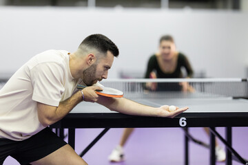 Man serving ping pong ball during table tennis game