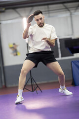 Fototapeta premium Young man playing table tennis at training session