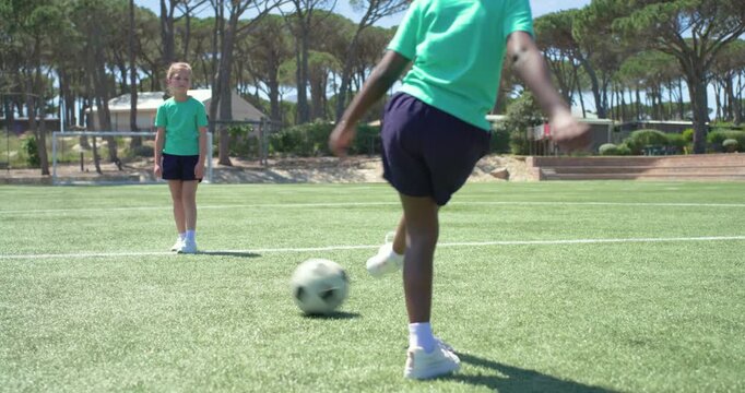Three youth female players starting drill, passing soccer ball on turf in teal shirts, copy space