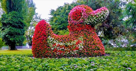 Bright Summer Scene With Decorative Floral Dog Surrounded By Trimmed Hedges And Lush Greenery