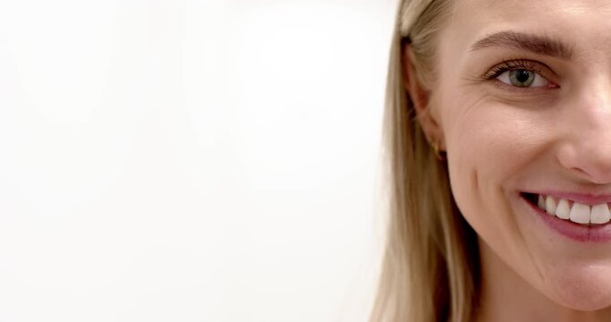 Woman following cue, smiling and opening, showing teeth, dimples in studio for portrait, copy space