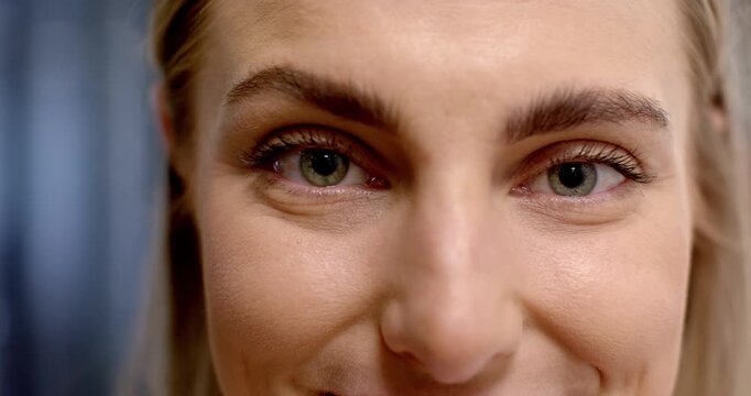 Adult woman reacting to camera in close-up blinking smiling for portrait showing dimples and teeth