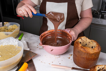 Confectioner checking the correct texture of the melted chocolate.