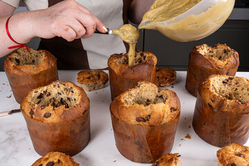 A confectioner filling panettones with pistachio cream.
