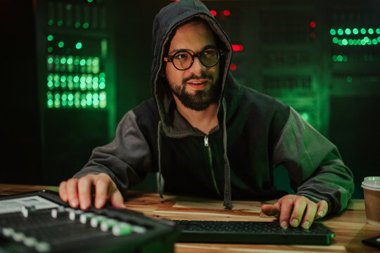 Hacker working on computer in server room at night - Powered by Adobe