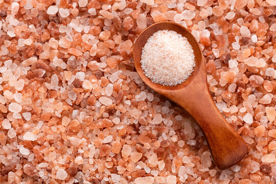 Spoon with fine grains of pink Himalayan salt - Fine crystals sprinkled.