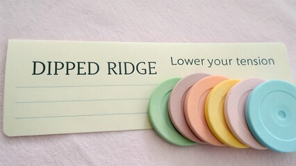 Colorful stress relief tool with labeled chart for tension management and relaxation techniques on a soft background