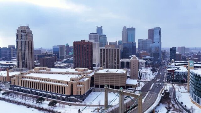 Minneapolis downtown skyline rises above snow-covered streets and historic buildings in aerial view