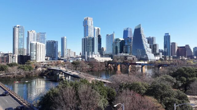 Austin Downtown and Skyline from Pfluger Pedestrian Bridge and MoPac Railroad Bridge over with Kayaks and Boats on Lady Bird Lake under Sunny Blue Sky