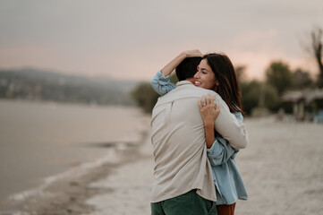 Happy couple embracing on the beach at sunset