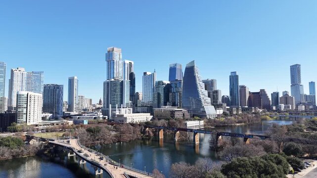 Austin Downtown and Skyline from Pfluger Pedestrian Bridge and MoPac Railroad Bridge over with Kayaks and Boats on Lady Bird Lake under Sunny Blue Sky