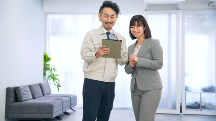 Fototapeta premium オフィスでタブレットを使って説明する作業員