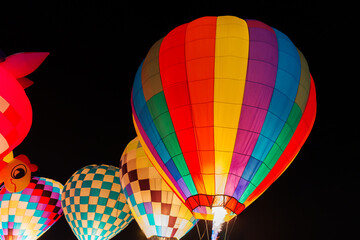 Obraz premium colorful hot air balloons glowing against dark night sky