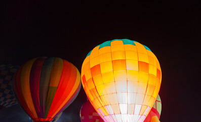 colorful hot air balloons glowing against dark night sky