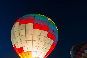 colorful hot air balloons glowing against dark night sky
