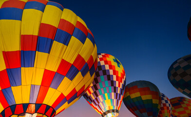 colorful hot air balloons glowing against dark night sky