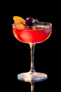 Manhattan cocktail served up garnish with a Bordeaux cherry and an orange twist