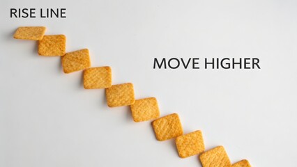 Creative design concept showcasing rise line made of snack pieces with motivational text Move Higher on a white background