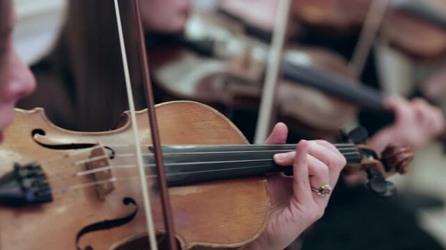 Close-Up of Violinist&rsquo;s Hands Playing the Strings with a Bow