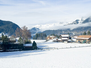 Beautiful early morning, snowy and foggy panorama shots of the Swiss Alps with saturated sun rays amidst early morning fog.  