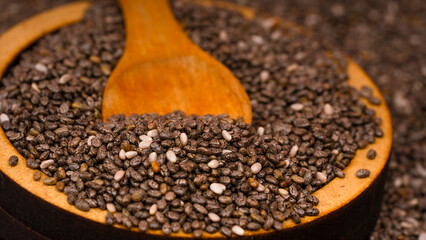 Chia seeds in a wooden bowl with a wooden spoon