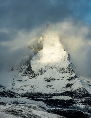 Sun Trying To Break The  Swirling Fog Over The Matterhorn