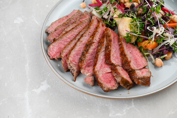 Close up of New York Strip Steak Served with Mixed Greens Salad