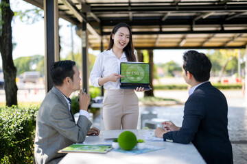 Businesswoman presenting esg sustainability data outdoors to colleagues