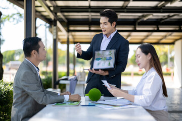 Business people discussing green energy recycling presentation at outdoor meeting
