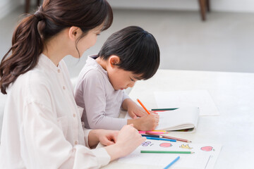 家でお絵描きする子供とママ