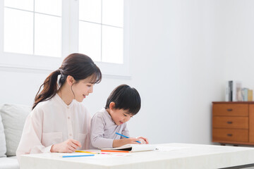 家でお絵描きする子供とママ