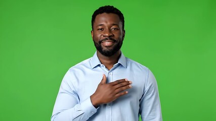 Smiling African American man with hand on heart expressing sincerity on green screen background