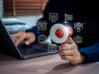 Online advertising and digital marketing concept with hand holding megaphone and icon overlays, representing promotion strategy, SEO, social media ads, content marketing, and audience targeting.