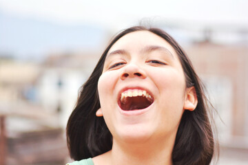 Happy teenager girl laughing out aloud.