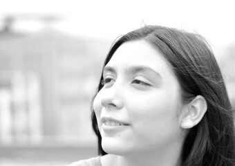 Preteen latin girl smiling dreamfully.