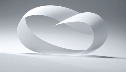 White paper strip twisted into a Mobius strip shape, casting shadows