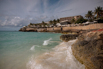 Resorts, waves and soft sand at Maho Beach in St. Maarten, a famous destination for sunbathing, swimming, and plane spotting.
