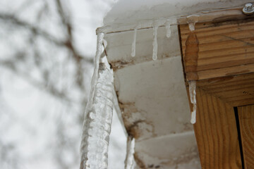 Obraz premium A close-up of icicles hanging from a snowy roof