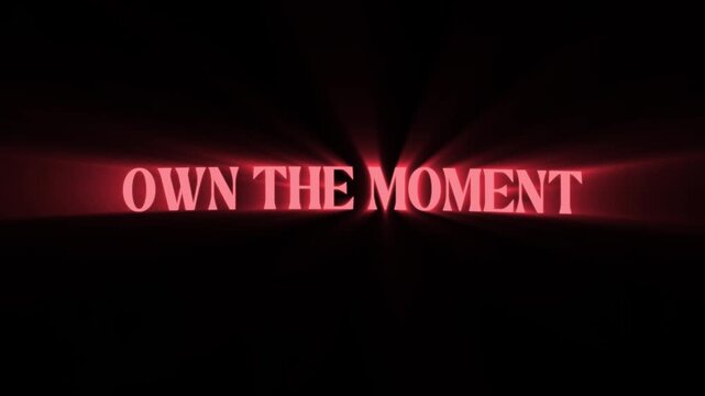 Own the moment inspirational quote with bright light beams emanating from the text on a dark background