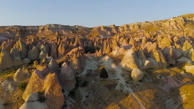 Goreme, Nevsehir, Turkey. Evening aerial view of Devrent Valley colorful rock formations and whimsical erosion patterns in Cappadocia during sunset.. Aerial View