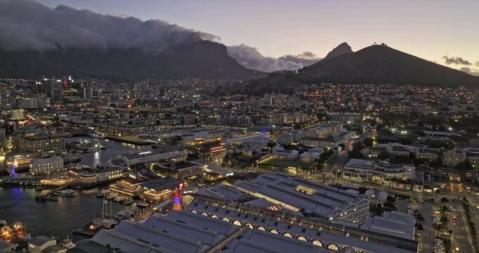 Cape Town South Africa Aerial v19 flyover Victoria and Alfred Waterfront, capturing illuminated cityscape at dusk with Table Mountain in the background - Shot with Mavic 3 Pro Cine - Jan 10th 2024