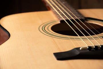 Close-up acoustic guitar, focusing on the strings.