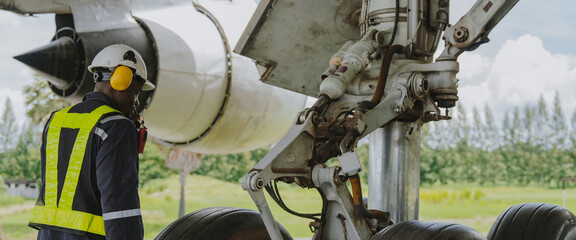 Mechanics inspect the engines of a large plane before takeoff at a summer airport.(PHOTO)