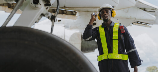 Mechanics inspect the engines of a large plane before takeoff at a summer airport.(PHOTO)