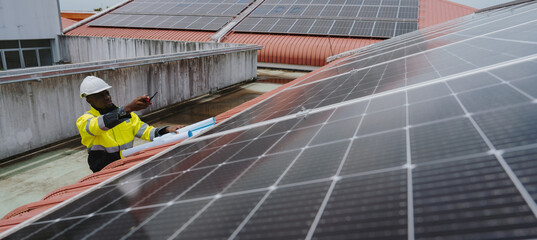 Engineers are checking the hot coil system of the rooftop air conditioner for green energy. Solar panels on the roof of the factory.(PHOTO)	